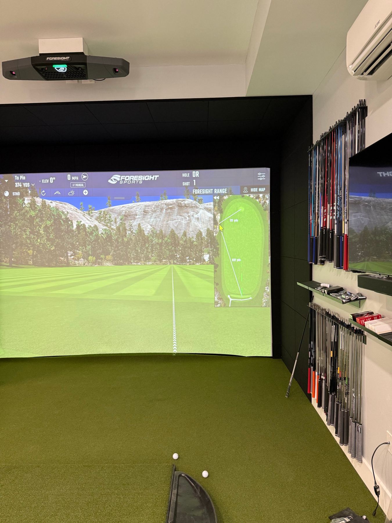 Built-in private studio with overhead launch monitor and a wall of shafts.